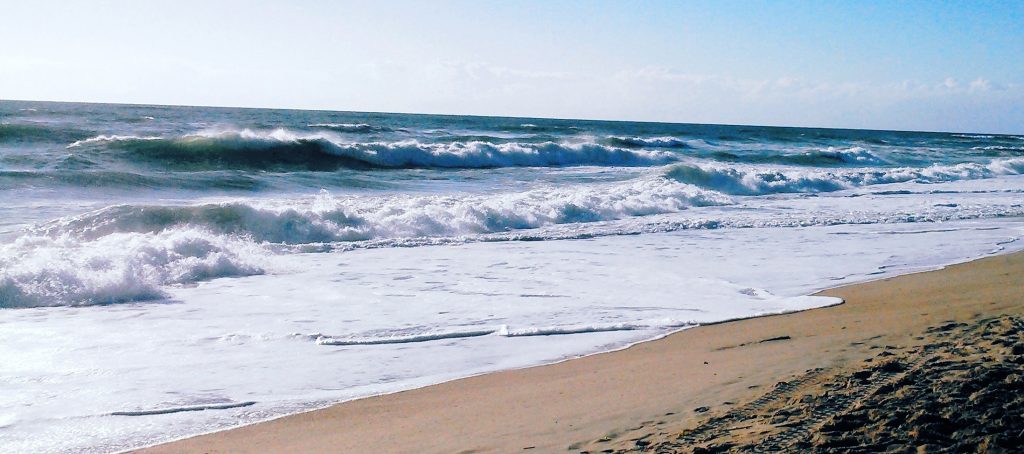 Summer morning on the beach. Rough ocean